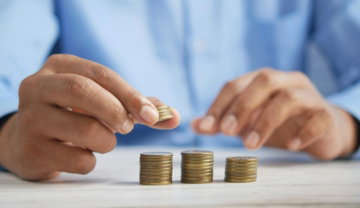 a person stacking coins on top of a table
